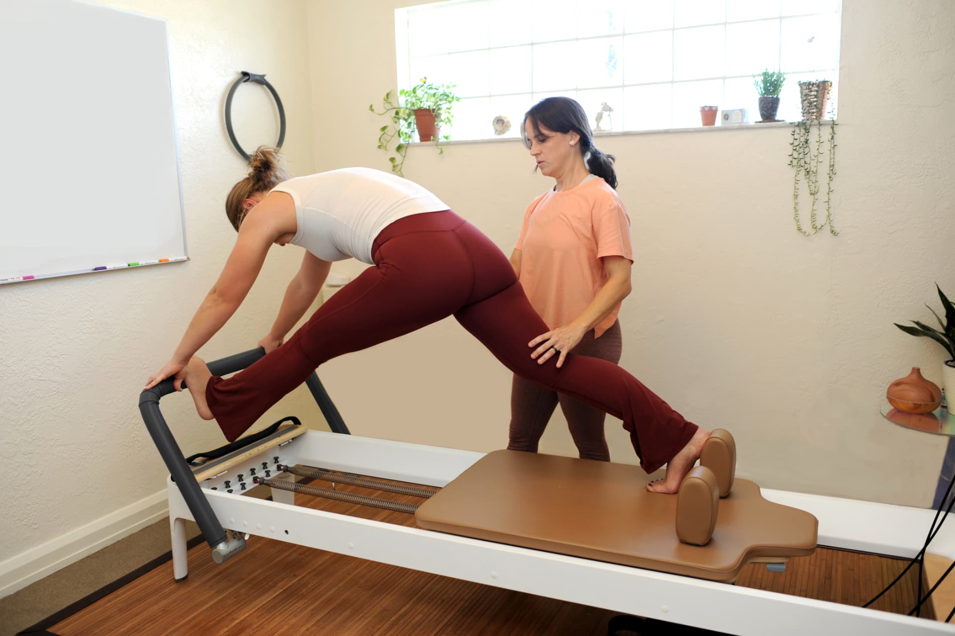 Standing lunge stretch on the reformer with hands-on cueing